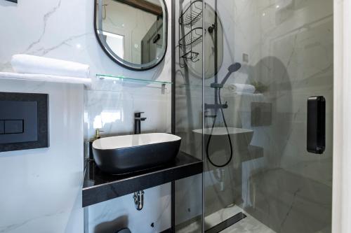 a bathroom with a sink and a mirror and a shower at Villa Dommy Gabby in Dubrovnik