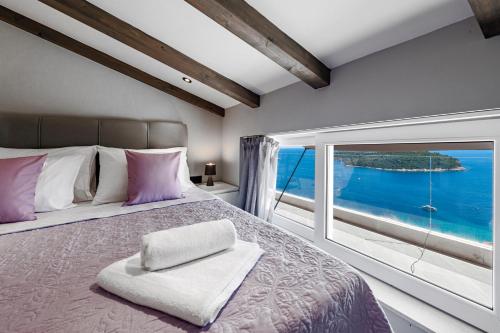 a bedroom with a large bed with a large window at Villa Dommy Gabby in Dubrovnik