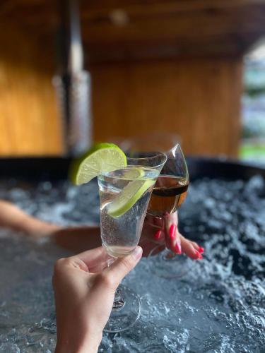 a person holding a drink with a lime on the counter at Apartmánový dom Adriana in Zuberec