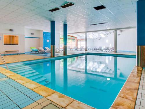 une grande piscine avec de l'eau bleue dans un immeuble dans l'établissement La Rosalie des Alpes - Ski l'hiver, rando l'été !!! - A deux pas des pistes !, à La Féclaz