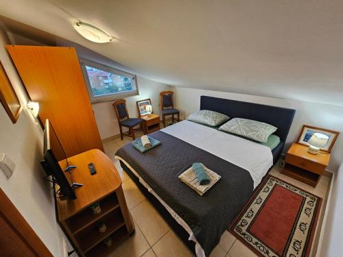 a small bedroom with a bed and a table at Sunset View Biograd in Biograd na Moru