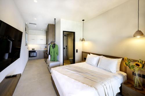 a bedroom with a large white bed and a kitchen at Dedalos Touch Boutique Hotel in Skaleta