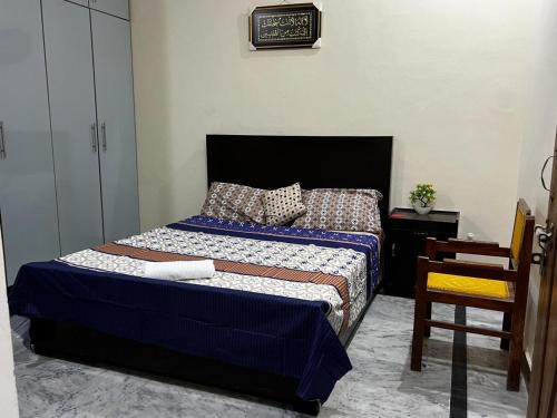 a bedroom with a bed with blue sheets and pillows at House for Short Term Renting in Sargodha