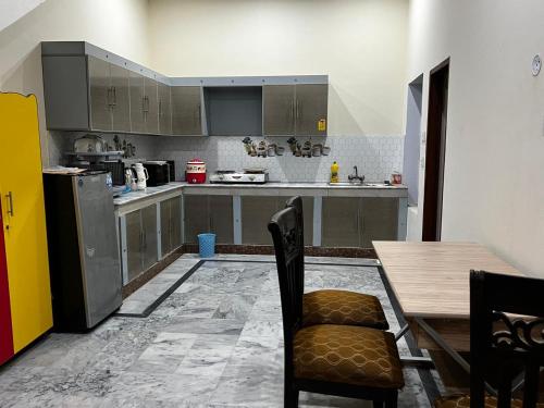 a kitchen with a wooden table and a table and chairs at House for Short Term Renting in Sargodha