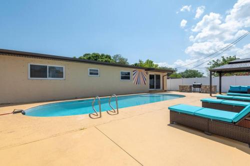 a swimming pool with blue lounge chairs next to a building at Cruise-Ready Oasis 15min to Beach & Port Canav & Huge Pool in Cocoa