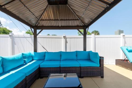 a blue couch sitting under a pergola on a patio at Cruise-Ready Oasis 15min to Beach & Port Canav & Huge Pool in Cocoa