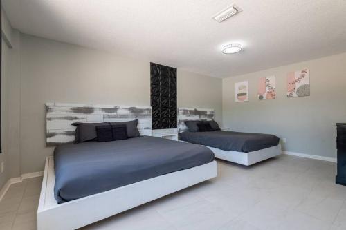 a bedroom with two beds with blue comforters at Cruise-Ready Oasis 15min to Beach & Port Canav & Huge Pool in Cocoa