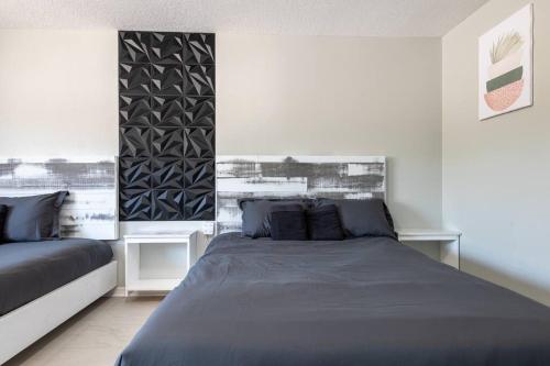 a bedroom with a bed and two tables in it at Cruise-Ready Oasis 15min to Beach & Port Canav & Huge Pool in Cocoa