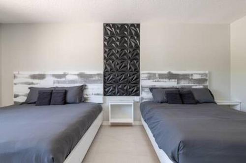 two beds sitting next to each other in a bedroom at Cruise-Ready Oasis 15min to Beach & Port Canav & Huge Pool in Cocoa