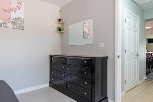 a bedroom with a black dresser in a room at Cruise-Ready Oasis 15min to Beach & Port Canav & Huge Pool in Cocoa