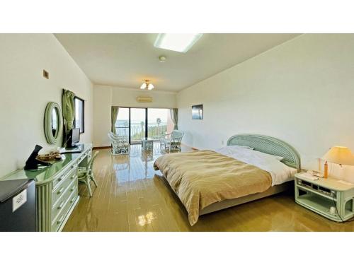 ein Schlafzimmer mit einem Bett und einem Schreibtisch mit einem Fernseher in der Unterkunft Umibe no Kajuen - Vacation STAY 17476v in Konan