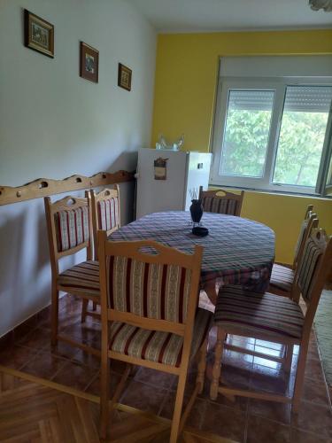 a kitchen with a table and chairs and a refrigerator at Vikendica NiNICA in Irig