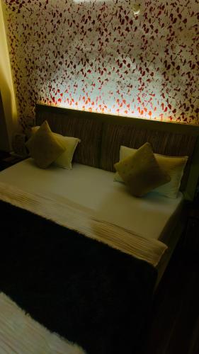 a bed in a room with a flowery wall at Hotel Apple Regency in Shimla