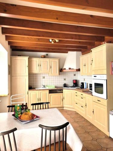 a kitchen with white cabinets and a table with chairs at Gîte de France Chez dédé et léa 3 épis - Gîte de France 6 personnes MAE-9414 in Sarroux
