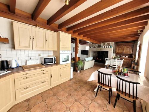 a kitchen with a table and a dining room at Gîte de France Chez dédé et léa 3 épis - Gîte de France 6 personnes MAE-9414 in Sarroux