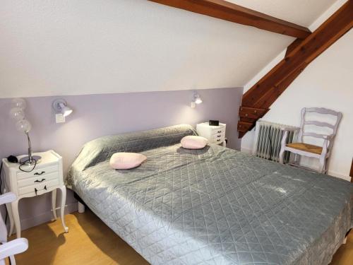 a bedroom with a bed with pink pillows on it at Gîte de France Chez dédé et léa 3 épis - Gîte de France 6 personnes MAE-9414 in Sarroux