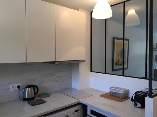 une cuisine avec des armoires blanches et un comptoir dans l'établissement Studio 33m2 avec Terrasse, à Cassis