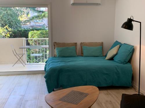 - une chambre avec un lit vert et une table dans l'établissement Studio 33m2 avec Terrasse, à Cassis