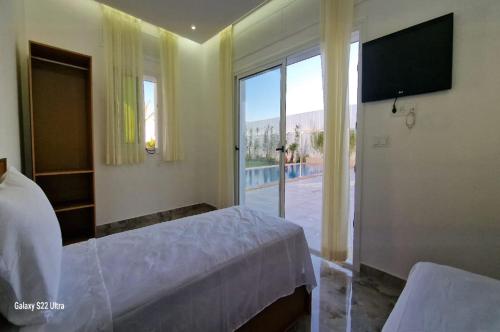a bedroom with a bed and a large window at Villa Fares Assilah 2 in Asilah