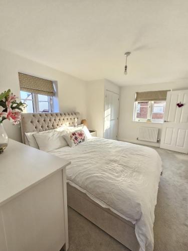a white bedroom with a large bed in a room at Bicester Kingsmere Accommodation with Ensuite in Bicester