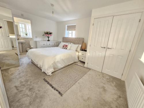 a white bedroom with a bed and a large closet at Bicester Kingsmere Accommodation with Ensuite in Bicester