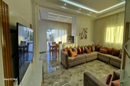 a living room with two couches and a television at Villa Fares Assilah 2 in Asilah