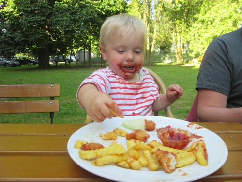 a young child eating a plate of food at Hotel Villa Wirtshaus Köpenick in Hofgeismar