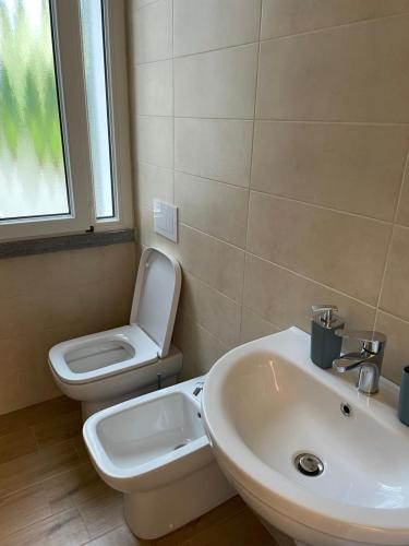 a bathroom with a white sink and a toilet at Acquadolce Apartment in Baveno