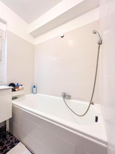 La salle de bains blanche est pourvue d'une baignoire blanche. dans l'établissement Bel appartement très bien situé Cannes Croisette, à Cannes