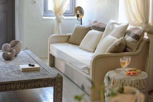 a living room with a couch and a table at Wonderful Santorini Villa Alia Mansion 3 Bedrooms Beautiful Outdoor Space & Wonderful Views Megalochori in Megalokhori