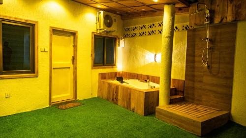 Un baño con lavabo y ducha con césped verde. en Villa avec Jacuzzi en Côte d'Azur, en Cotonou