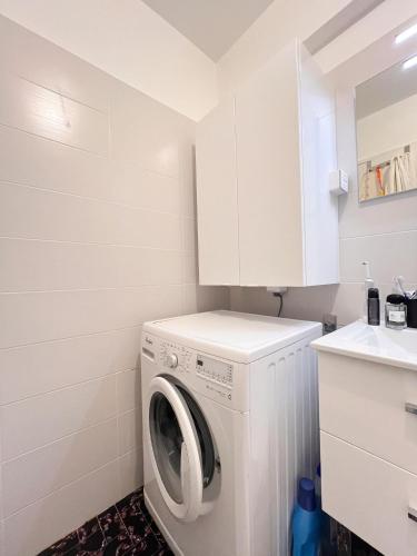 - un lave-linge et un sèche-linge blancs dans une petite salle de bains dans l'établissement Bel appartement très bien situé Cannes Croisette, à Cannes