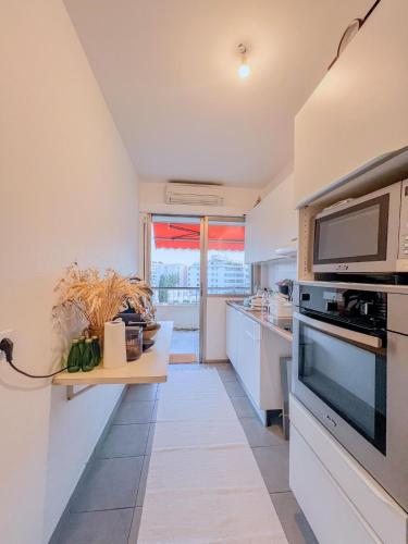 - une cuisine avec des comptoirs blancs et un four micro-ondes dans l'établissement Bel appartement très bien situé Cannes Croisette, à Cannes