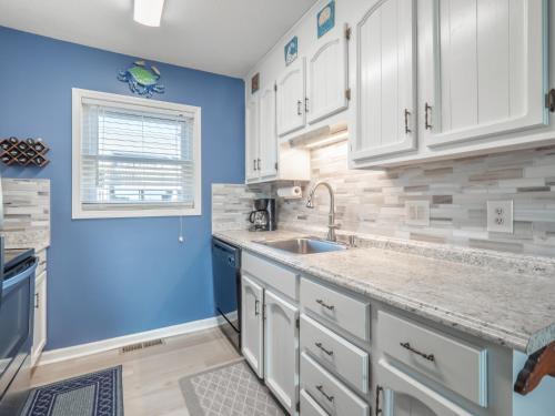 a kitchen with white cabinets and a sink at Sands III #2B - A BluSea in Carolina Beach