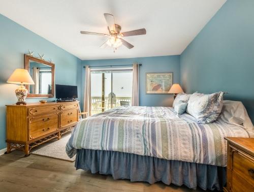 a bedroom with a bed and a ceiling fan at Sands III #2B - A BluSea in Carolina Beach