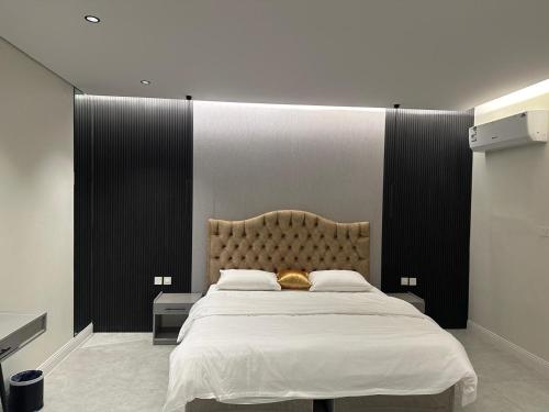 Un dormitorio con una cama grande con un cabecero grande. en شاليه لينا الفندقيه, en Medina