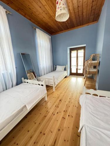 a room with two beds and a wooden floor at Traditional maisonette just 15' from Kalamata in Valíra
