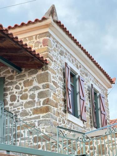 a stone building with two windows and a balcony at Traditional maisonette just 15' from Kalamata in Valíra