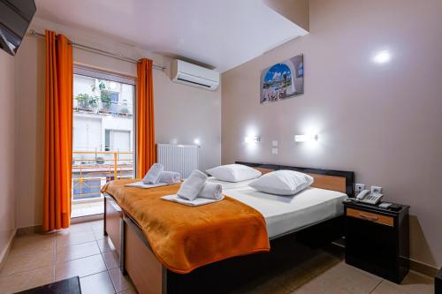 a bedroom with a bed and a window with orange curtains at Faros I in Piraeus
