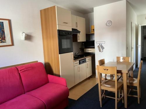 un salon avec un canapé rouge et une table dans l'établissement LE CHALET - Piscine 2 - Studio pour 4 Personnes MAE-8694, à Gourette