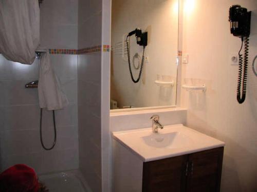 La salle de bains est pourvue d'une douche, d'un lavabo et d'un téléphone. dans l'établissement LE CHALET - Piscine 2 - Studio pour 4 Personnes MAE-8694, à Gourette