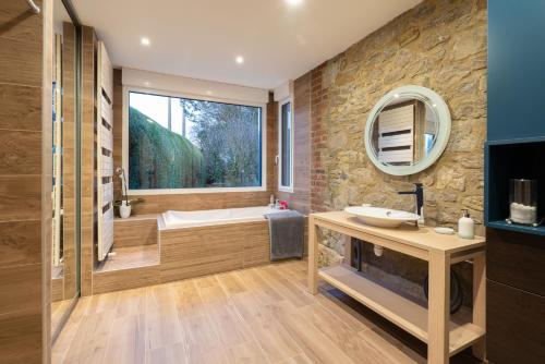 a bathroom with a tub and a sink and a mirror at OPARADI "La Villa Nature" - Parfaite pour les GROUPES in Belle-et-Houllefort