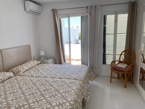 a bedroom with a bed and a large window at Casa Los Remos in La Marina de la Torre