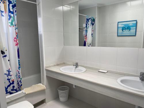a bathroom with two sinks and a mirror at Casa Los Remos in La Marina de la Torre