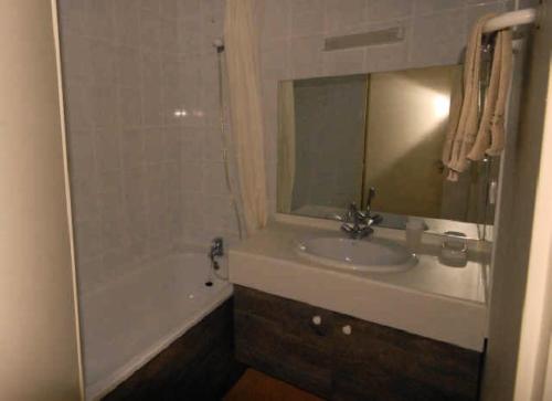 une salle de bain avec un lavabo, une baignoire et un miroir dans l'établissement LE CHALET - Piscine 17 - 2 Pièces pour 6 Personnes MAE-8864, à Gourette