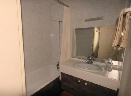 une salle de bain avec un lavabo, une baignoire et un miroir dans l'établissement LE CHALET - Piscine 20 - 2 Pièces pour 6 Personnes MAE-8874, à Gourette