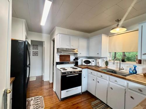 a kitchen with white cabinets and a stove top oven at Cabin Nestled on Skiers Cove South Toledo Bend Lake 3 bedroom-5 beds in South Toledo Bend