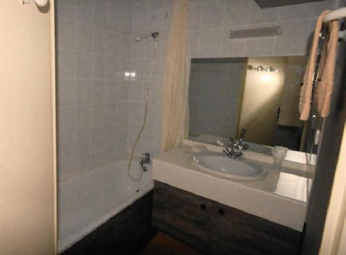 une salle de bain avec un lavabo, une baignoire et un miroir dans l'établissement LE CHALET - Piscine 16 - Studio pour 6 Personnes MAE-8824, à Gourette