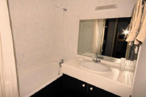 une salle de bain blanche avec un lavabo et un miroir dans l'établissement LE CHALET - Piscine 8 - Studio pour 4 Personnes MAE-8894, à Gourette