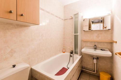 une salle de bain avec une baignoire et un lavabo dans l'établissement Résidence LES COTES - Studio pour 3 Personnes MAE-9594, à Aime La Plagne